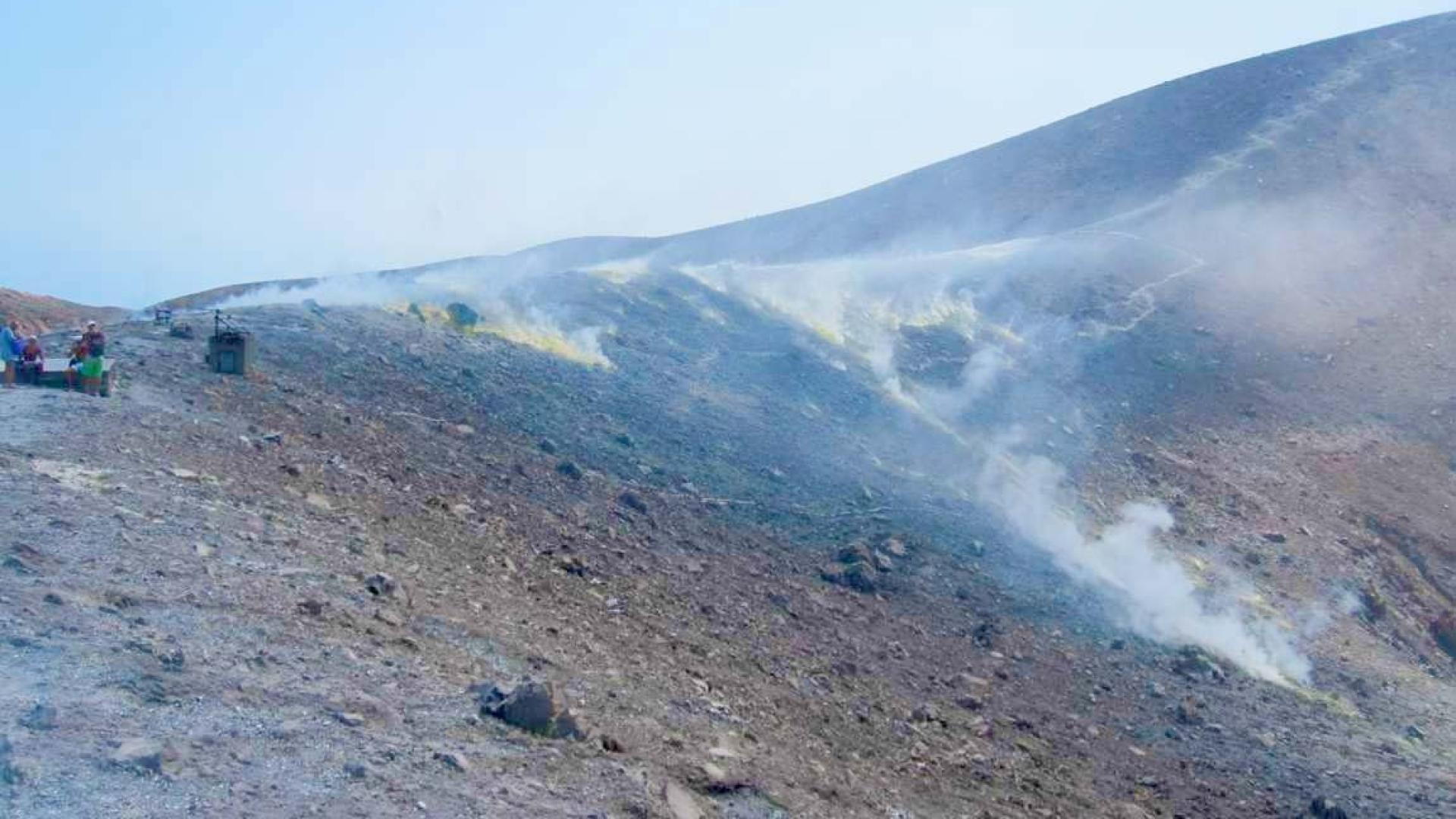 Paesaggio vulcanico fumante, terreno arido e roccioso, atmosfera surreale e affascinante.