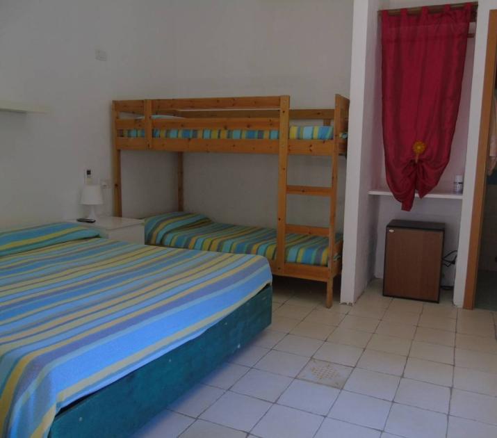 Camera accogliente con letti a castello, copriletti colorati e bagno privato.