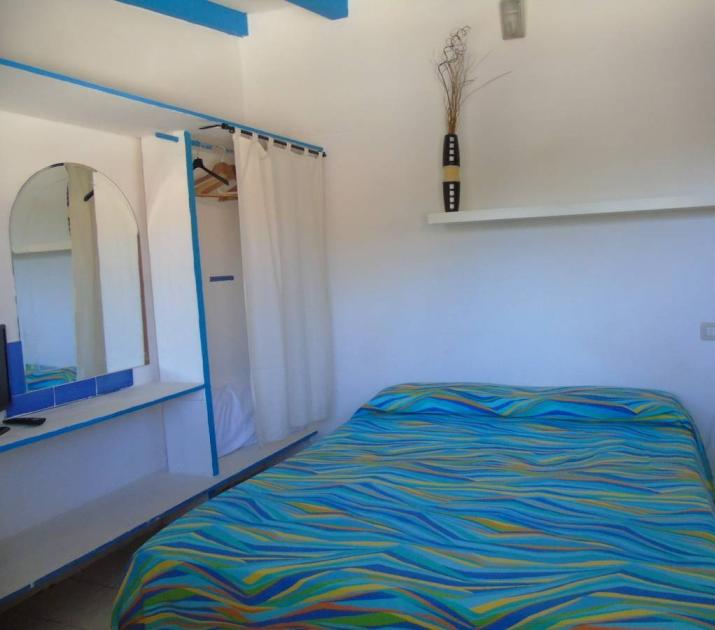 Camera luminosa con letto colorato, atmosfera rilassante e dettagli moderni.