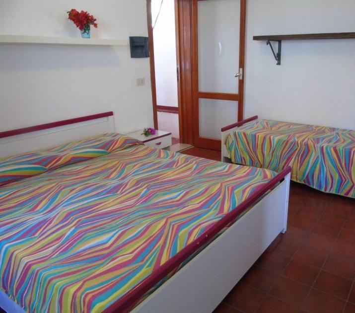 Camera accogliente con letti colorati e atmosfera vivace, ideale per un soggiorno rilassante.